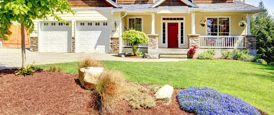 Well-maintained yard in Olathe, KS, with landscaping and mulch.