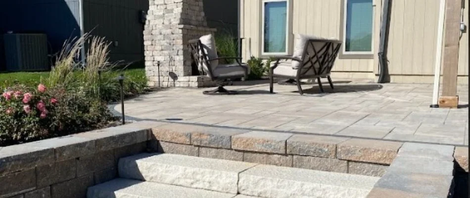 Patio with chairs and outdoor fireplace on a property in Olathe, KS.