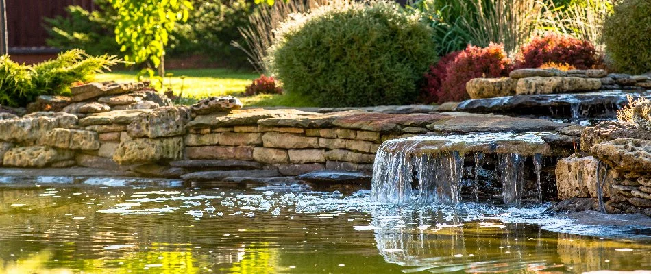 Pond with a waterfall on a property in Olathe, KS.