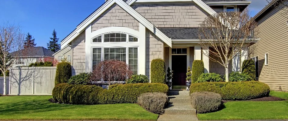 Home in Olathe, KS, with trees and shrubs.