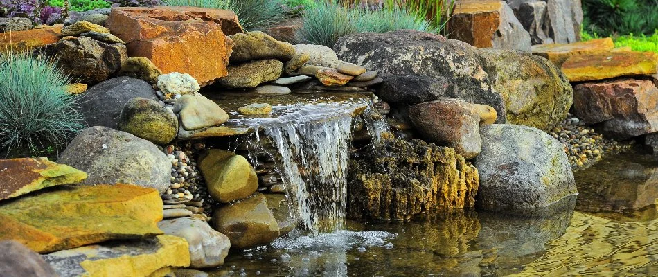 Waterfall feature with green plants in Olathe, KS.