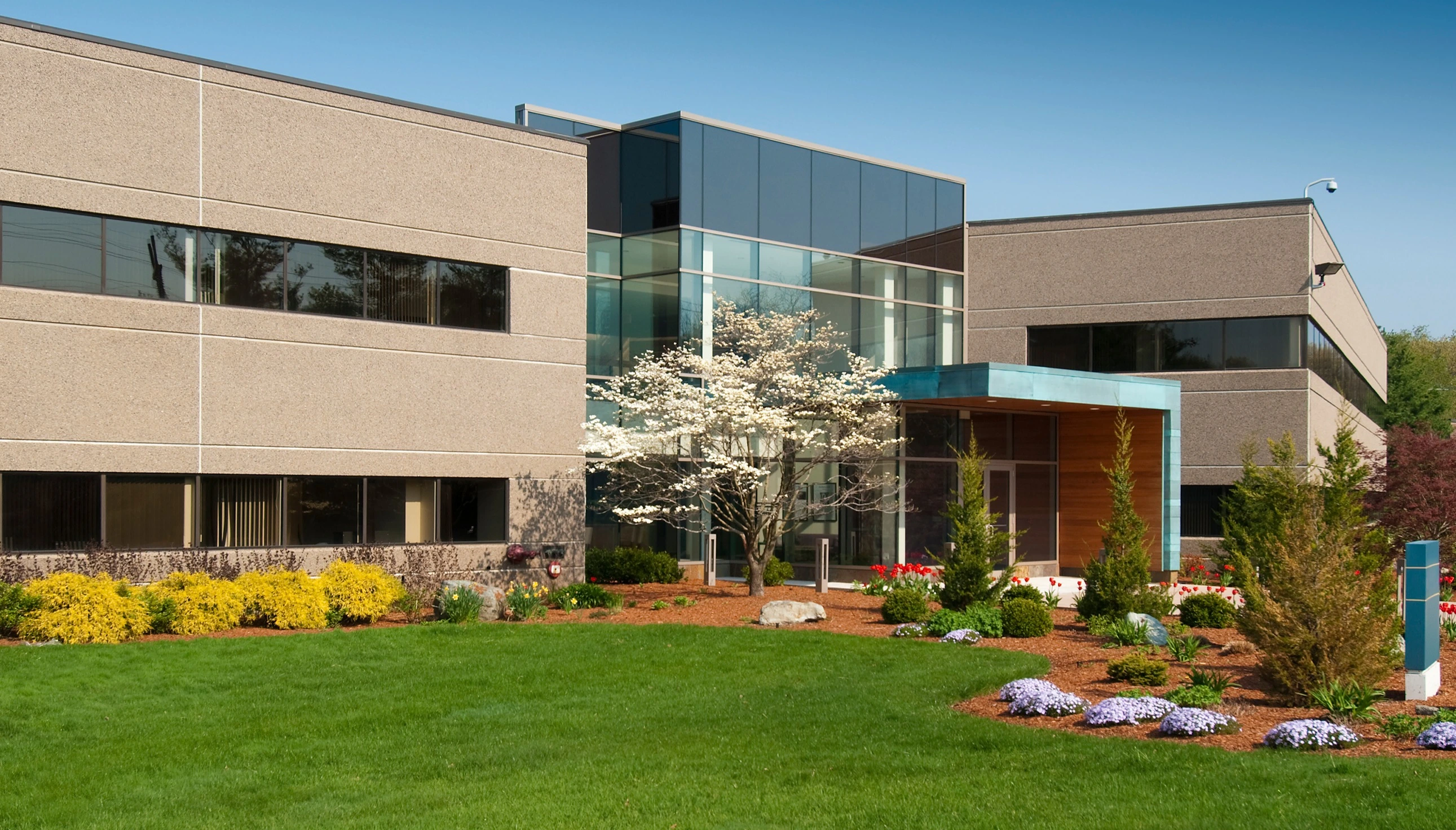 Outdoor living space with a fire pit and boulder retaining wall in Leawood, KS.